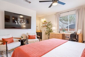 A modern bedroom with a bed, two armchairs, a desk, and a large window. - Family Retreat | Games, Fire Pit & Kids Barn (Austin)