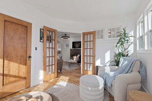 Un salon spacieux avec une cheminée, une grande fenêtre et un coin salon confortable.