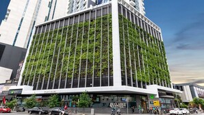 En moderne bygning med en facade dækket af grønne planter, der har en tydelig indgang med skilte for 'Metro' og '45 Clarke Street'.