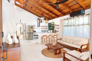 Cocina moderna con una isla central, taburetes de bar y una mesa de comedor.