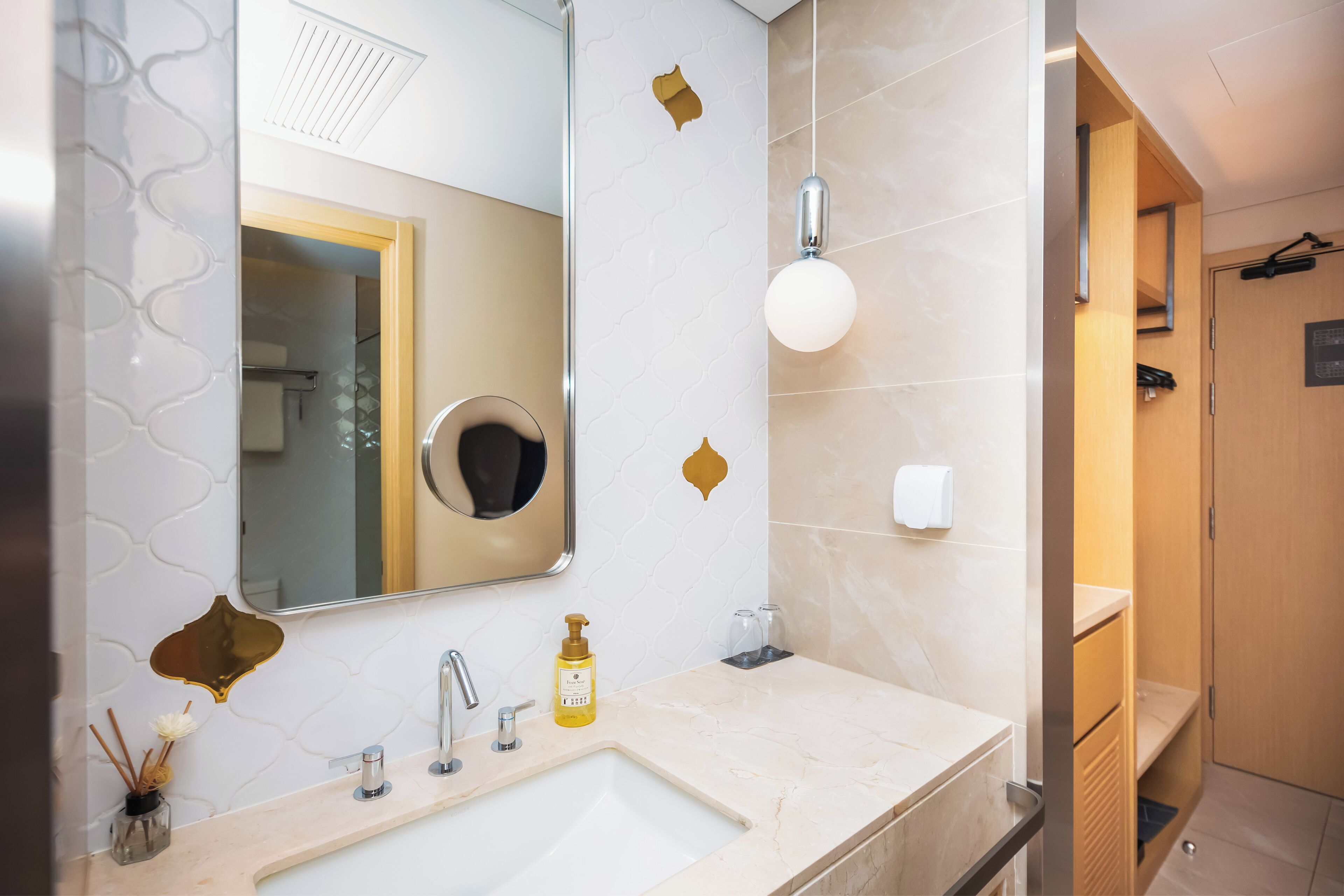 A bathroom with a sink, mirror, and towel rack.