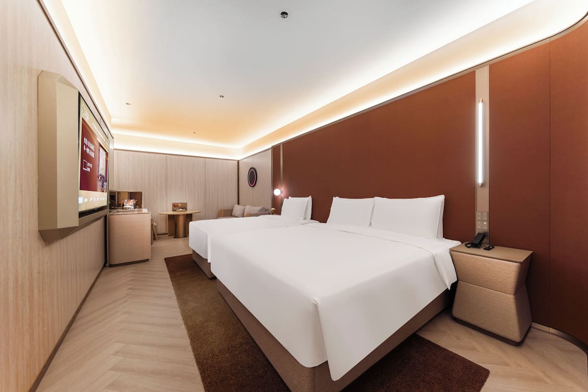 Een moderne hotelkamer met een groot bed, nachtkastjes, een bureau en een televisie.