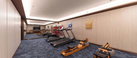 Gimnasio de hotel con cintas de correr, una máquina de remo y pelotas de ejercicio.