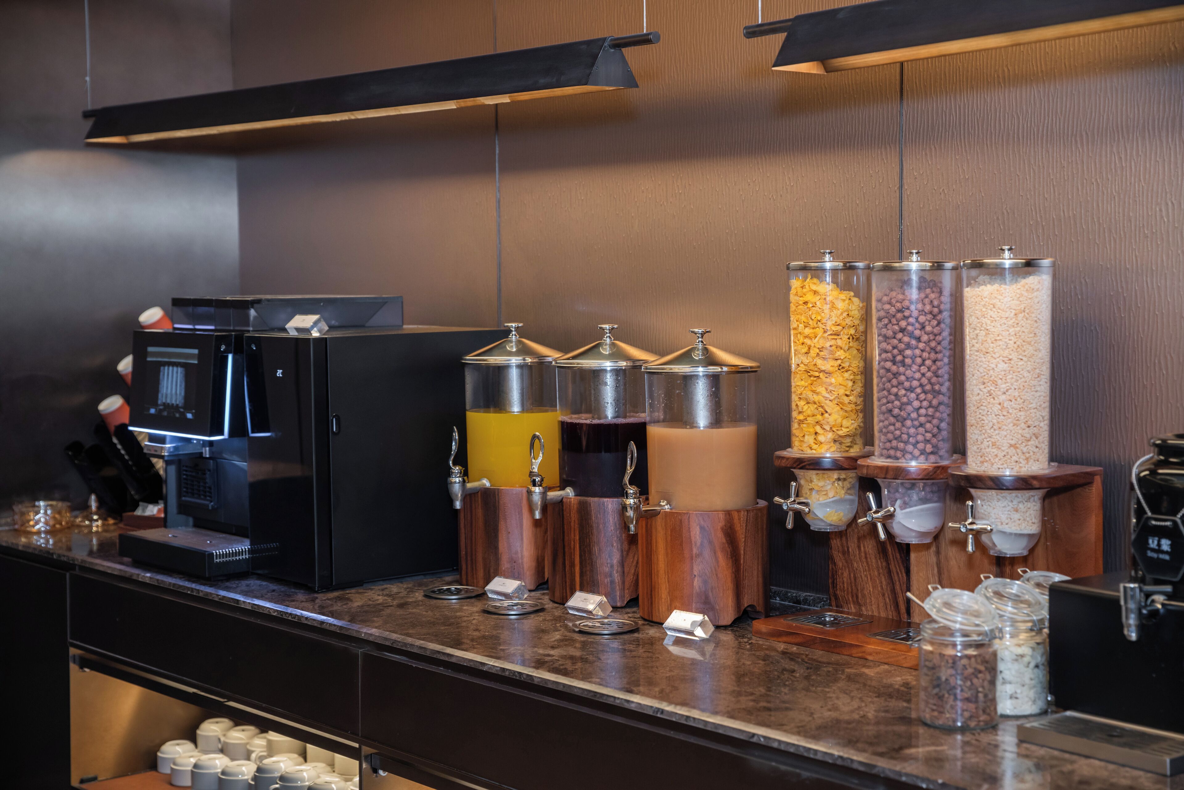 Una estación de café con una máquina de café y dispensadores para diferentes tipos de café molido y crema.