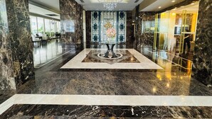 Un vestíbulo con piso de mármol, una mesa decorativa en el centro y una araña.