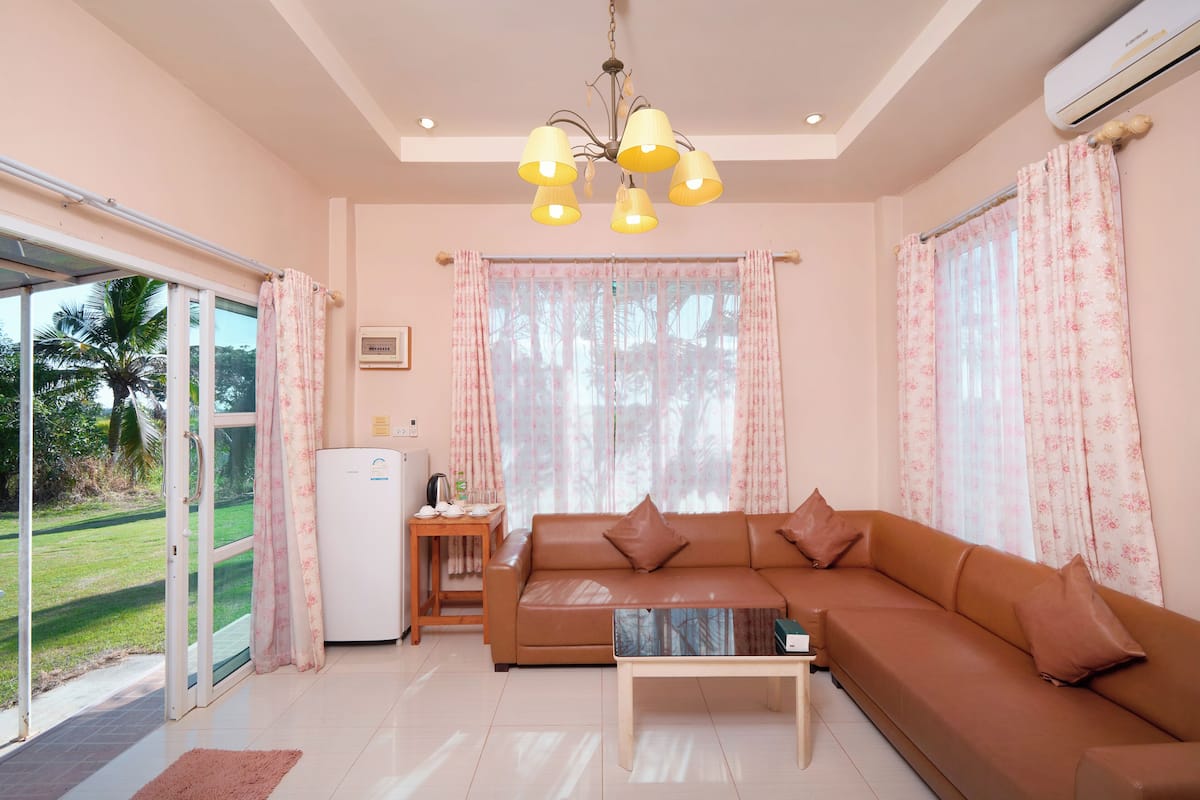 A living room with a sofa, a coffee table, and a ceiling light fixture.
