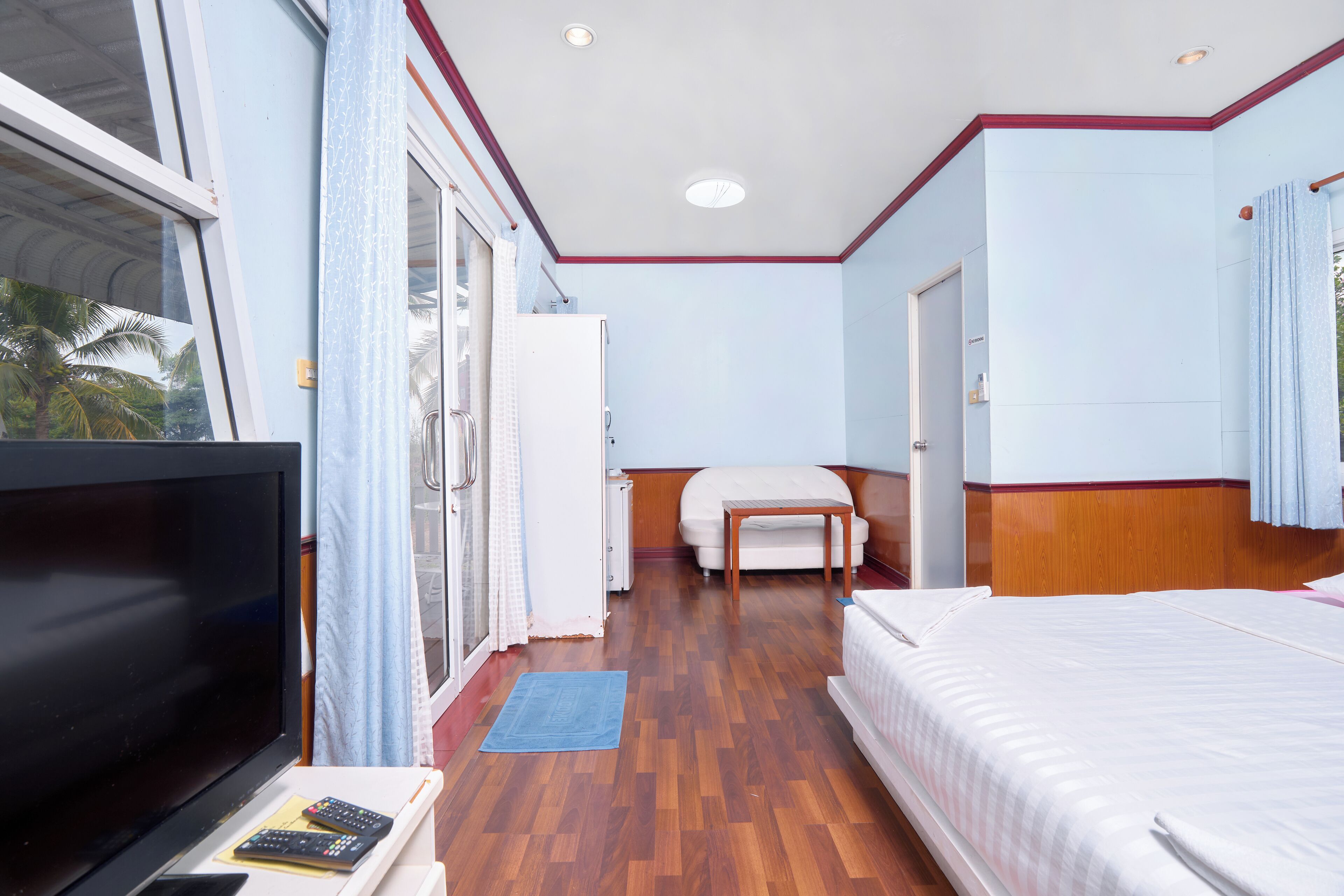 A hotel room with a bed, a TV, a desk, and a chair.