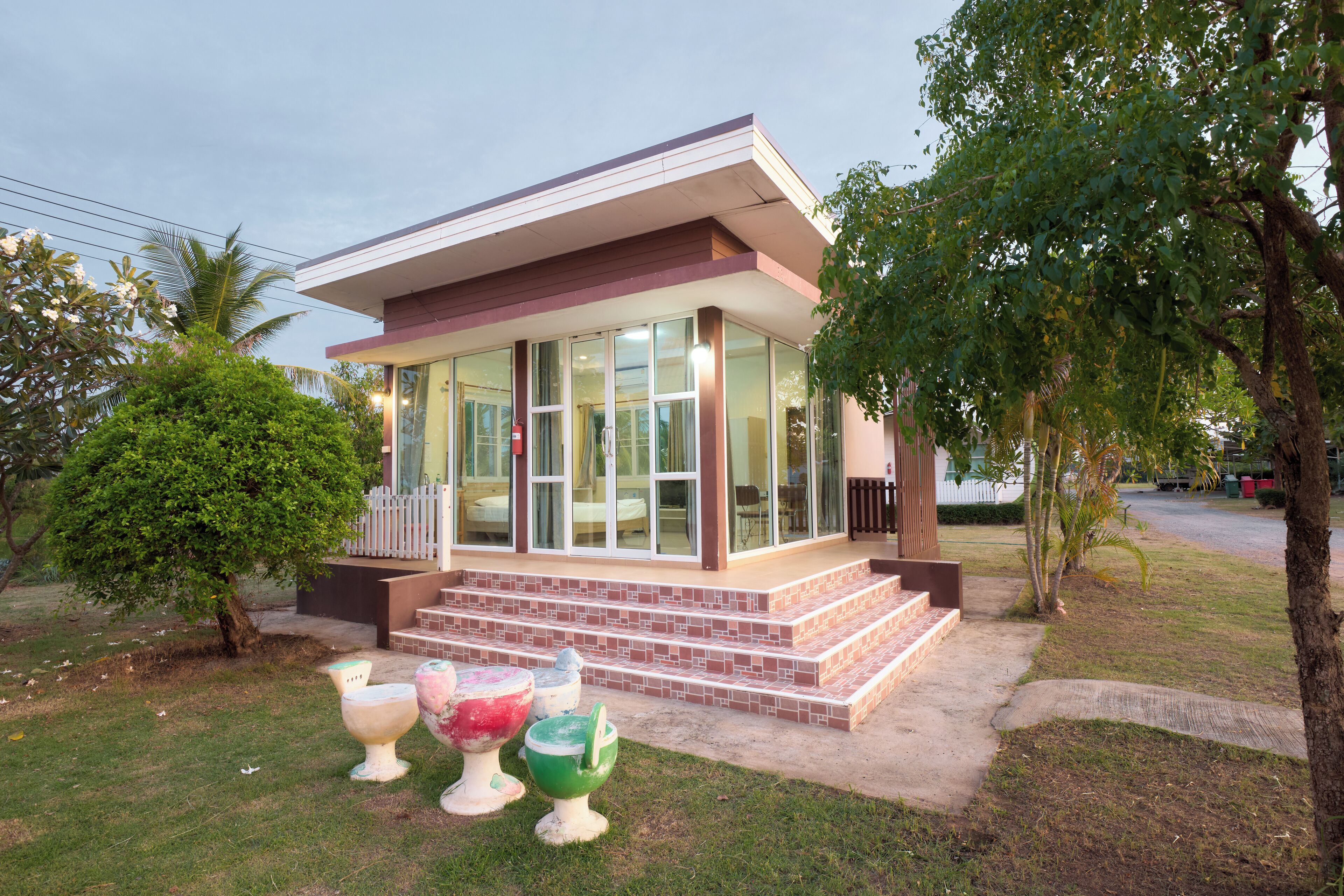 A modern house with a glass front, a porch, and steps leading to the entrance.