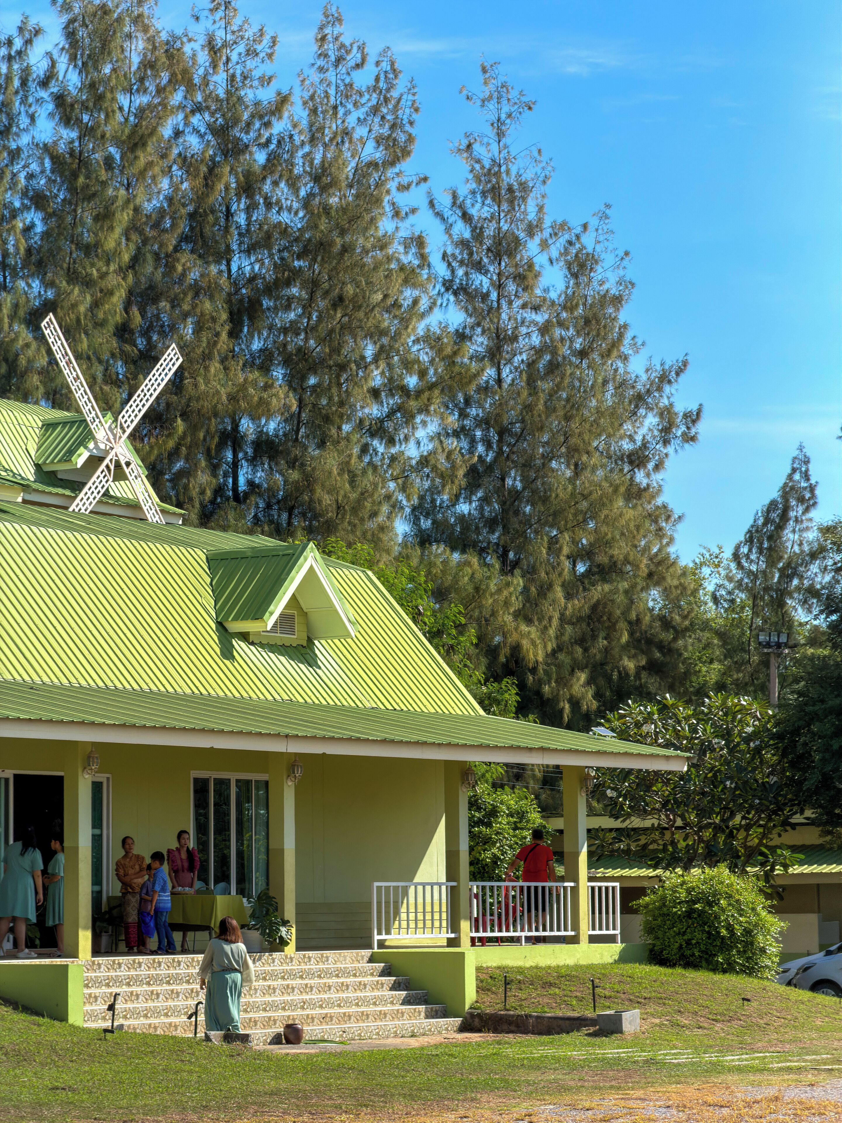 Un edificio con techo verde y un molino.