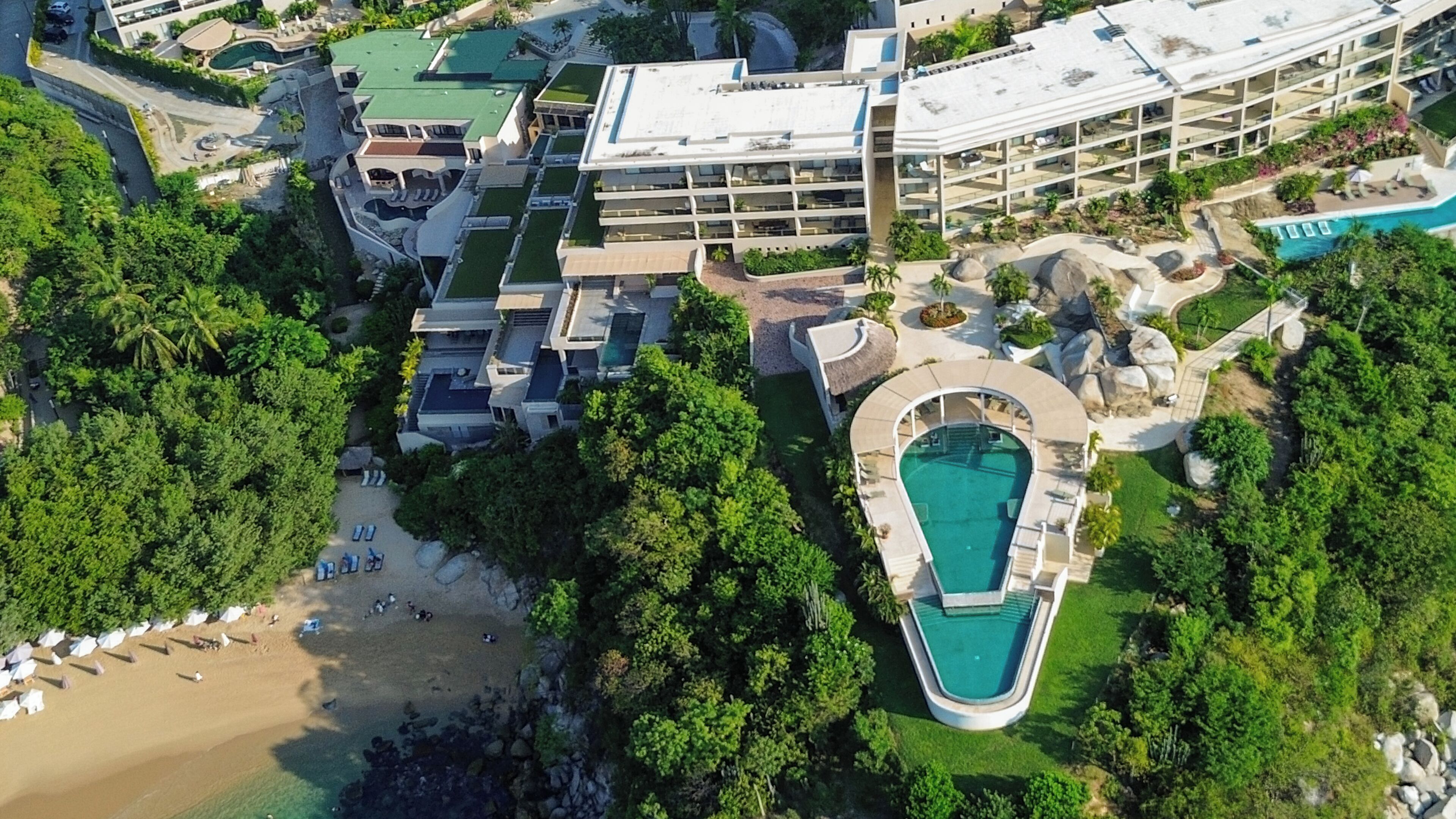 Un resort con varias construcciones, piscina y zona de playa.