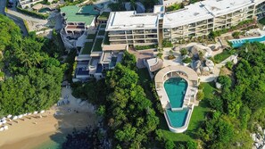 Un resort con varias construcciones, piscina y zona de playa.
