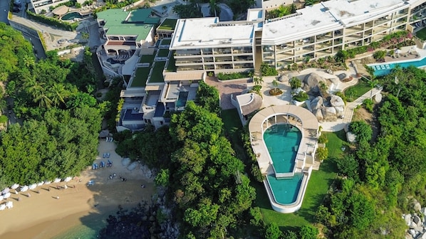 A resort with multiple buildings, a swimming pool, and a beach area. - The Sanctuary Boutique Hotel (Santa Maria Huatulco)