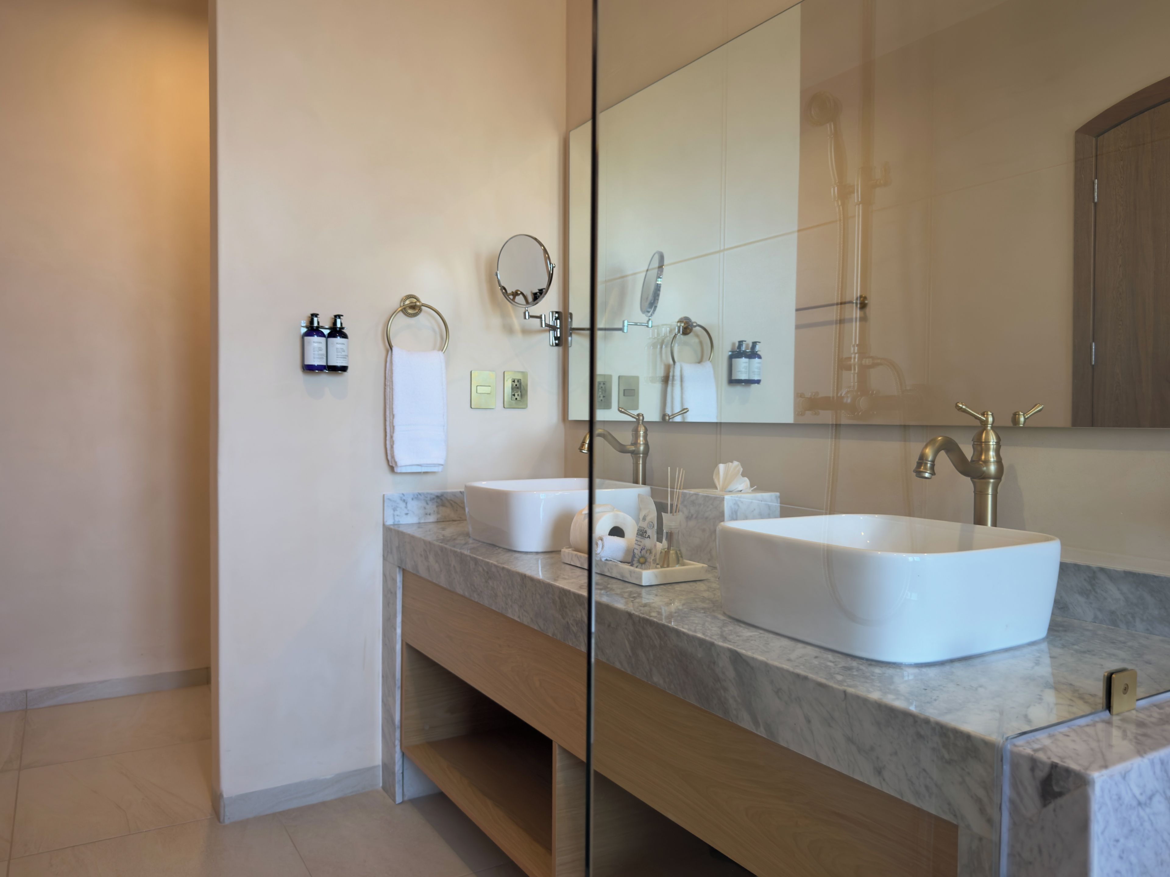 Un baño moderno con dos lavamanos, un espejo grande y un mueble de tocador de madera.