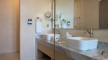 Un baño moderno con dos lavamanos, un espejo grande y un mueble de tocador de madera.