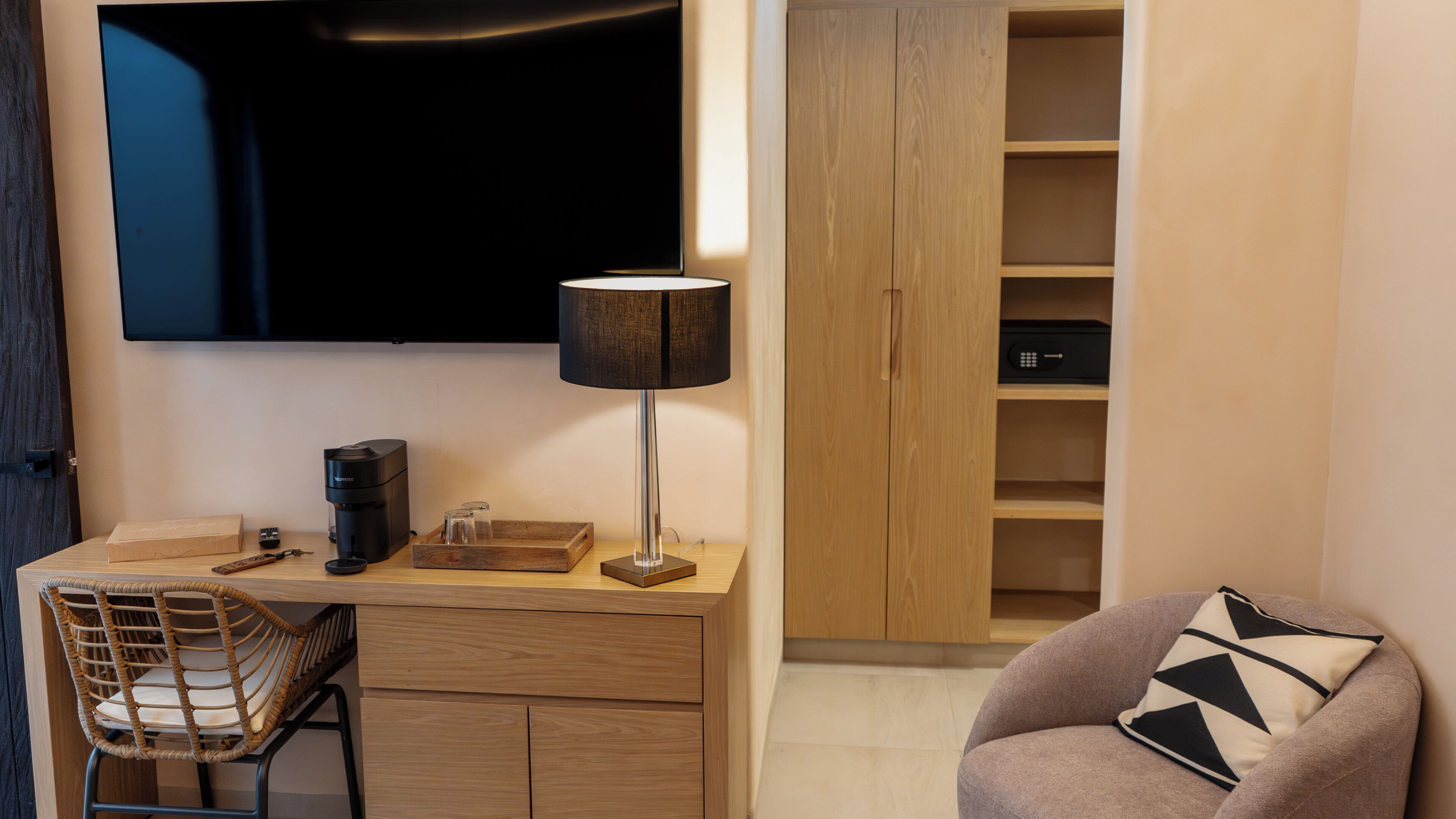 Une chambre moderne équipée d’un bureau en bois, d’un téléviseur à écran plat, d’une lampe, d’une chaise et d’une armoire.