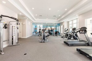 A gym with cardio machines, weightlifting equipment, and a mirrored wall. - Spacious 5-bedroom townhome in peaceful Kissimmee. Just 6 miles from Disney. (Kissimmee)