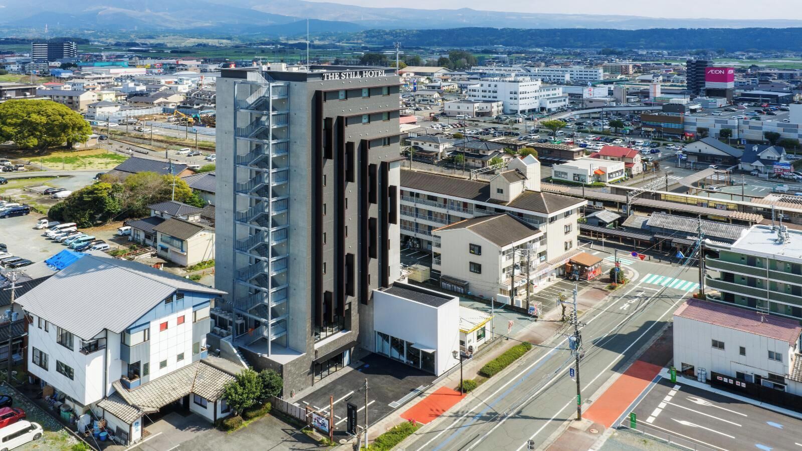 A modern hotel with multiple floors, a prominent staircase, and a view of the surrounding urban area.