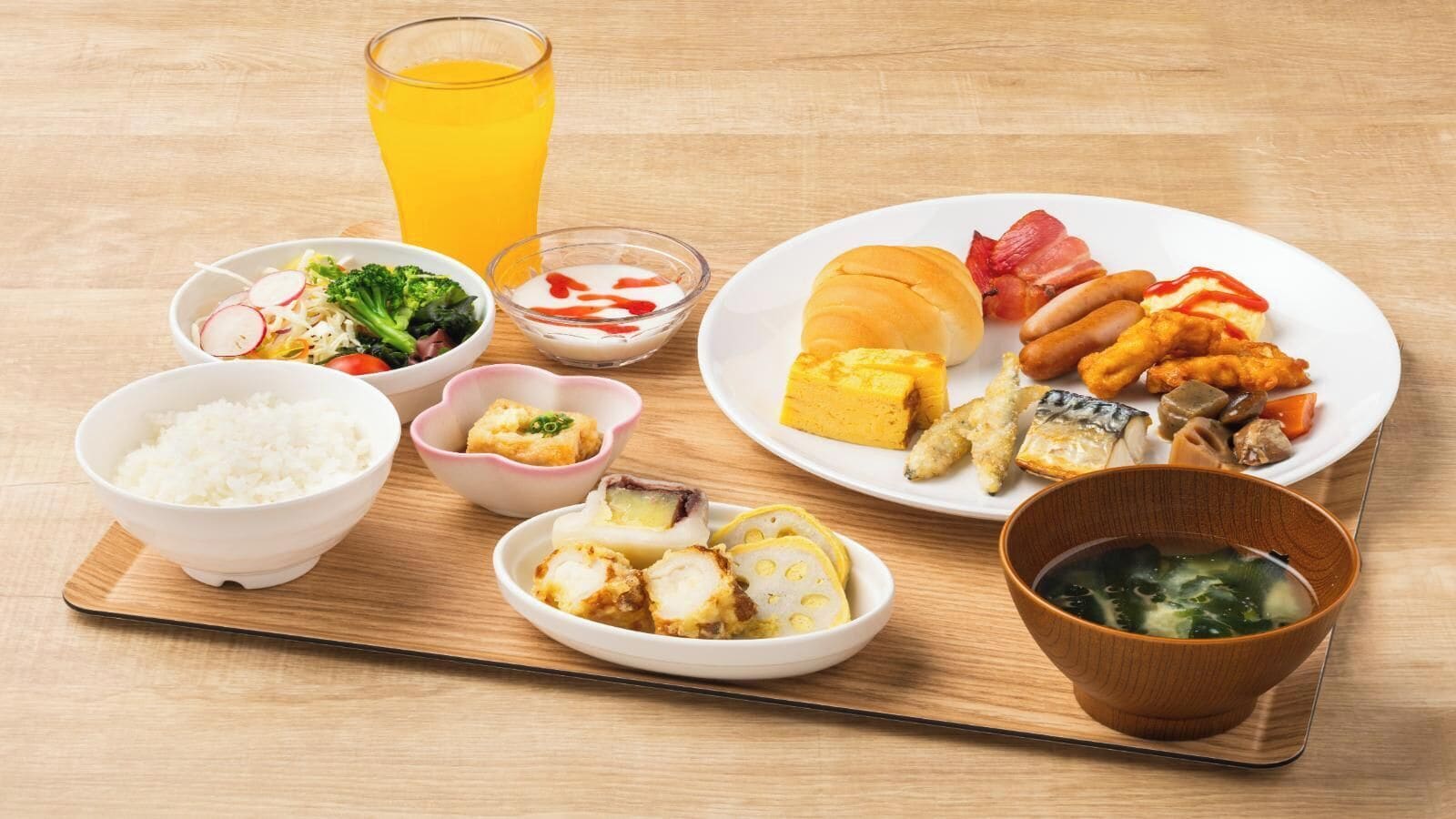 A meal with rice, vegetables, fish, and a drink on a wooden table.