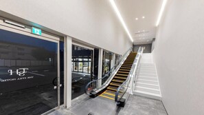 Entrada de hotel com escada rolante para o segundo andar.