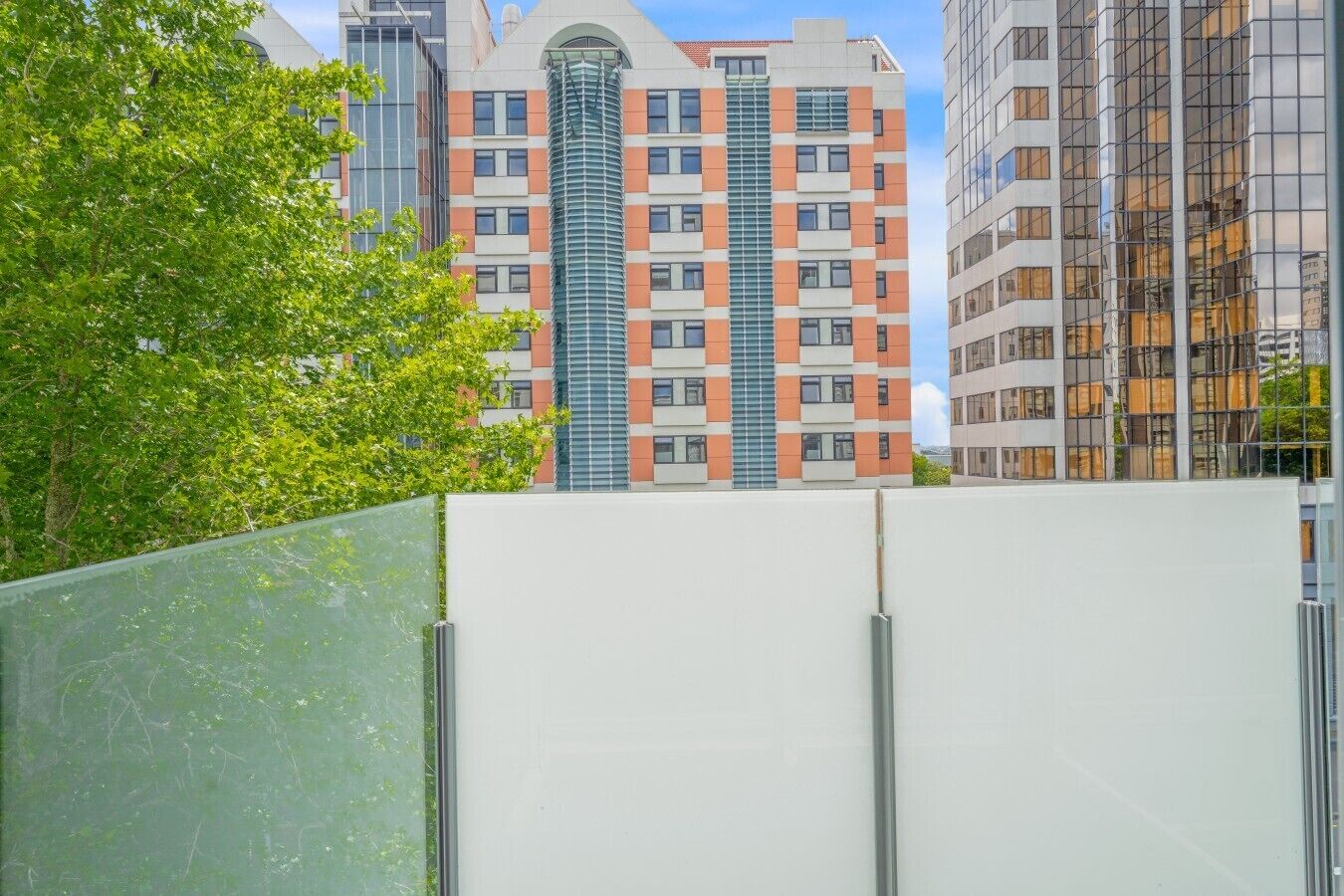 Een modern gebouw met een centraal glazen torentje, omgeven door andere gebouwen.