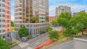 Een moderne stadsgrens met hoge gebouwen, een zebrapad en groene bomen.