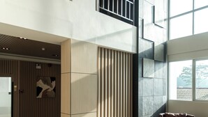 A modern lobby with high ceilings, large windows, and contemporary furniture. - River Hotel Hatyai (Hat Yai)