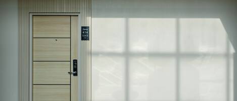 A door with a panel design, a sign indicating room number 414, and a shadow pattern on the wall.