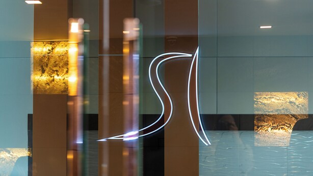 A modern interior with reflective surfaces and illuminated signage. - River Hotel Hatyai (Hat Yai)