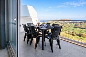 A dining area with a table set for four, overlooking a scenic landscape. - A Sunny Bay View + shared pool Gozo, Xagħra Gozo, Malta (Xagħra Gozo)