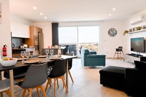 A modern apartment with a dining area, kitchen, living room, and balcony. - A Sunny Bay View + shared pool Gozo, Xagħra Gozo, Malta (Xagħra Gozo)