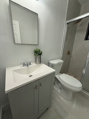 Een douche, handdoeken, zeep, toiletpapier