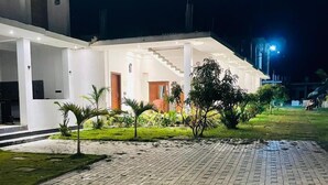 Un edificio moderno con un patio empedrado, una escalera y una entrada bien iluminada.