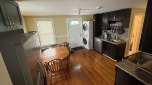 Una cocina compacta con comedor, electrodomésticos integrados y una pequeña isla.