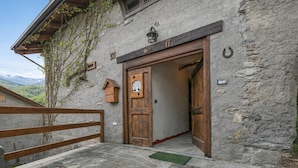 Un bâtiment rustique en pierre, doté d’une porte en bois, d’une petite cloche et d’une enseigne portant le numéro « 11 ».