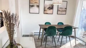 A modern dining area with a white table, green chairs, and a patterned rug. - Clean, quiet, 2-bedroom South Hill rental with a Garage. Conveniently located. (Spokane)