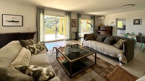 Ein Wohnzimmer mit zwei Sofas, einem Couchtisch und einem Klavier im Hintergrund.