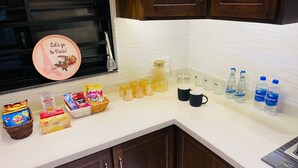 A kitchen counter with various food items, a coffee maker, and water bottles.