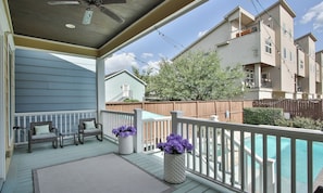 A covered outdoor deck with a pool, wicker furniture, and potted plants. - Downtown Houston-Private Pool, Hot Tub & Game Room (Houston)
