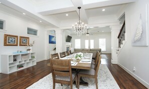 Comedor con una mesa de madera dispuesta para seis personas, rodeada de sillas, y un candelabro colgante.