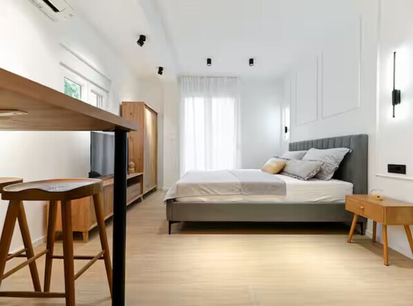 A modern bedroom with a bed, bedside table, and a wooden desk. - Zadar Apartment Sweet Life (Zadar)