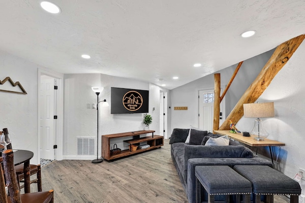 The living room has a cozy sofa and a large HD TV.