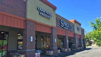 Un edificio con letreros que dicen 'Farm Fresh Produce' y 'Sprouts Farmers Market'.