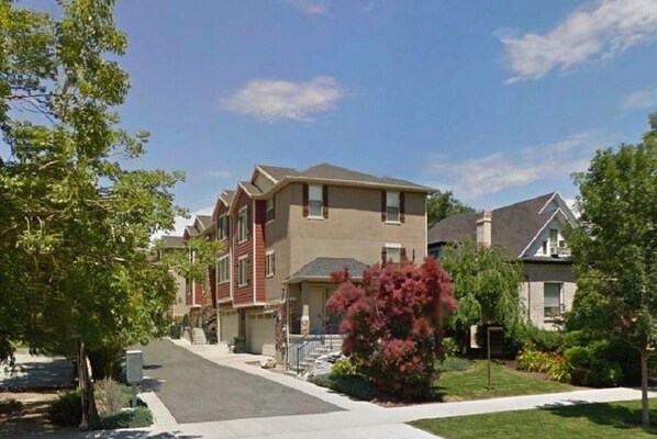 A row of townhouses with a central driveway, surrounded by greenery and trees. - Spacious Townhome Near Downtown (Salt Lake City)