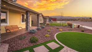 A residential property with a well-maintained lawn, a patio with a bench, and a driveway leading to the house. - Modern Wine Country Escape in the Verde Valley + Fire Pit + Sleeps 6+ (Cottonwood)