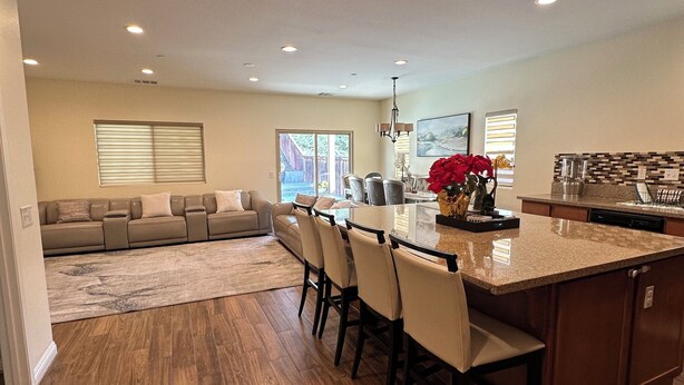 A spacious kitchen with a central island, dining area with chairs, and a living room with a sofa. - Quiet Modern Home Spacious & Work-Friendly (Beaumont)