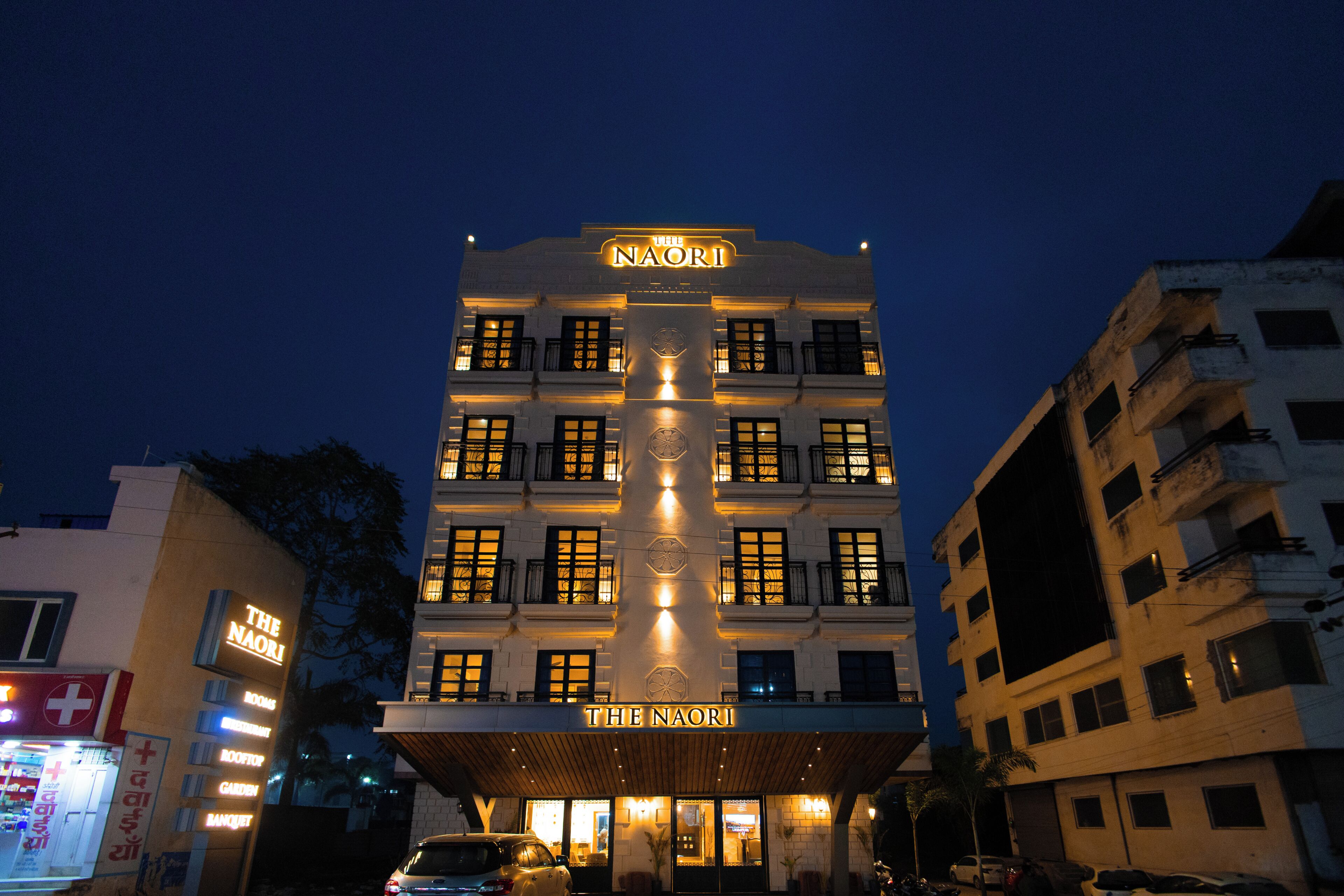 A multi-story hotel with illuminated signage, balconies, and a prominent entrance.