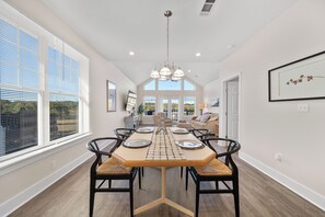 A dining area with a wooden table, black chairs, and a chandelier. -  Diamondhead Retreat – Perfect for Spring Break near Lake Catherine State Park ! (Hot Springs National Park)
