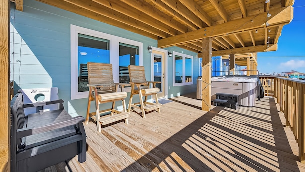 Une terrasse en bois avec des sièges d’extérieur et un jacuzzi.