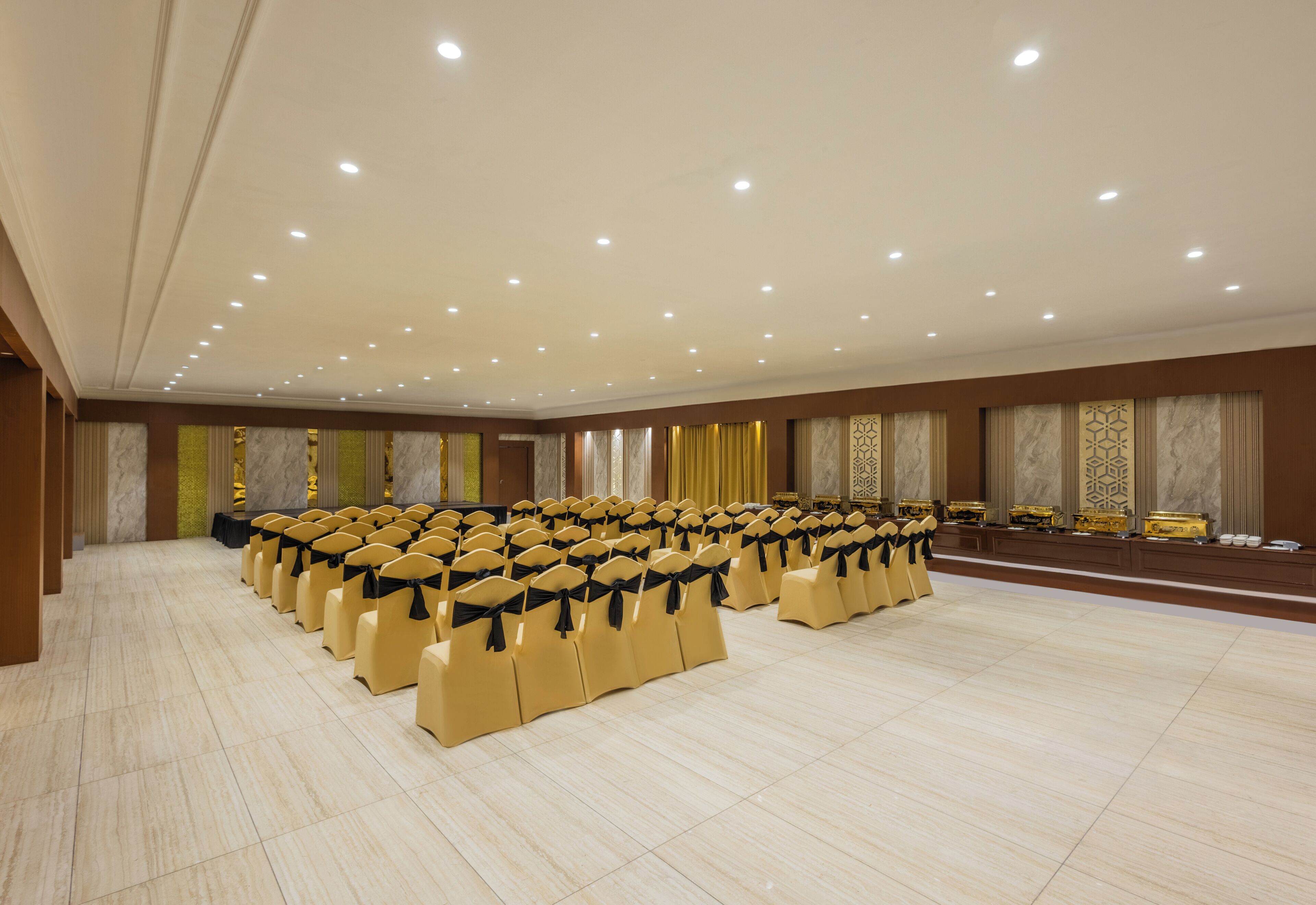 A large conference room with rows of chairs, a stage, and a polished floor.