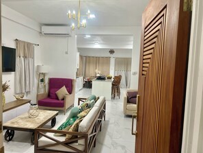 A modern living room with a sofa, a dining area, and a kitchen in the background. - This newly built, spacious three-bedroom home is ideally located in Rodney Bay. (Castries)